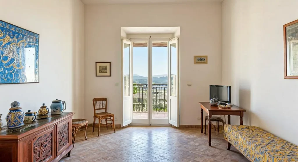 Intérieur lumineux d'un appartement typique à Catane avec hauts plafonds et éléments architecturaux siciliens, illustrant le type de logement disponible à la location pour les expatriés français en Sicile